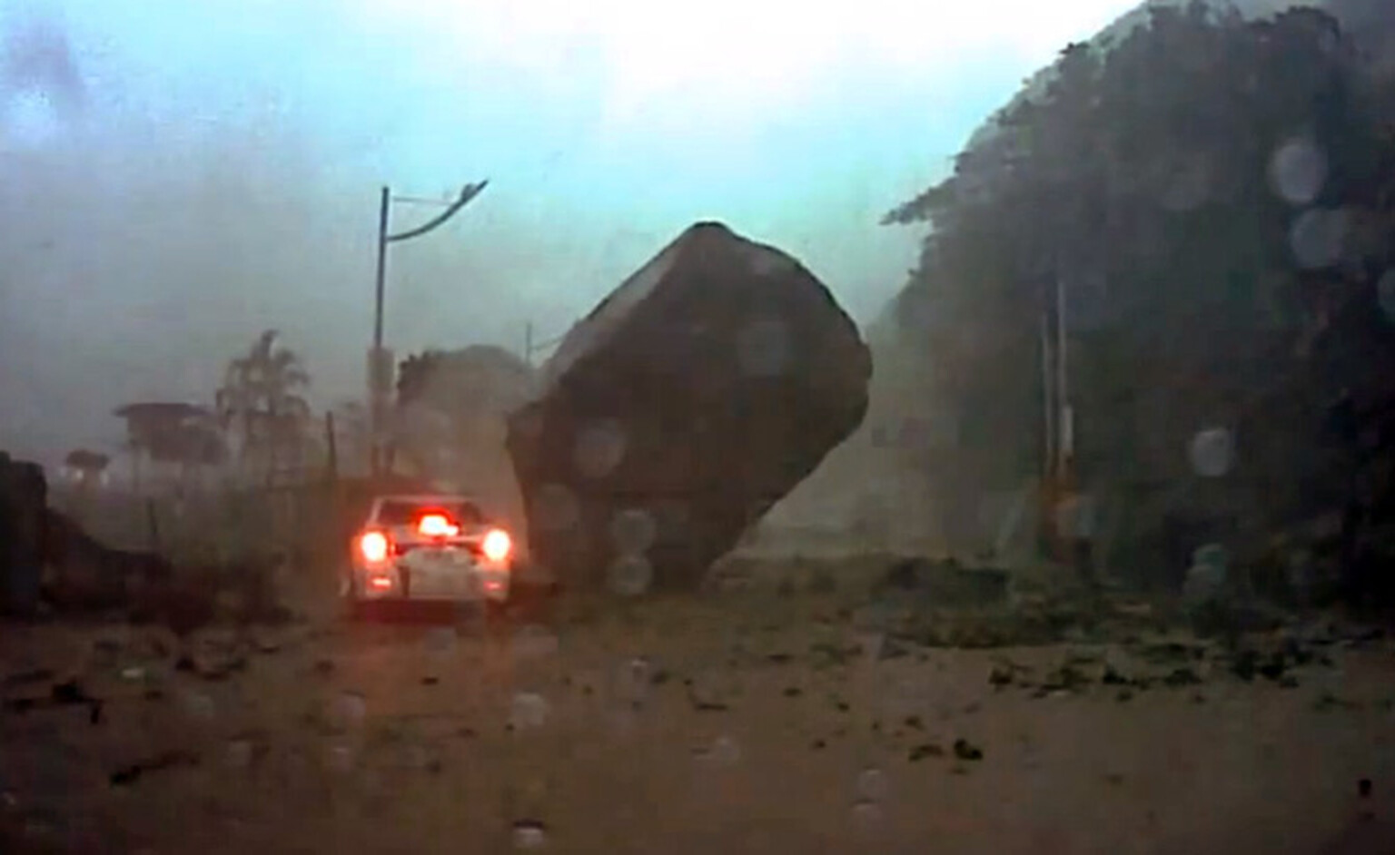 Car narrowly avoids boulder the size of a house during mud storm