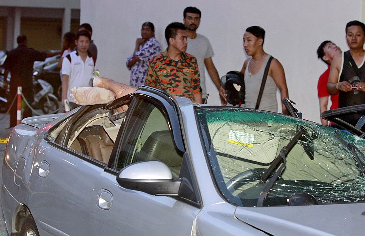 Motorist trapped after body lands on roof of car