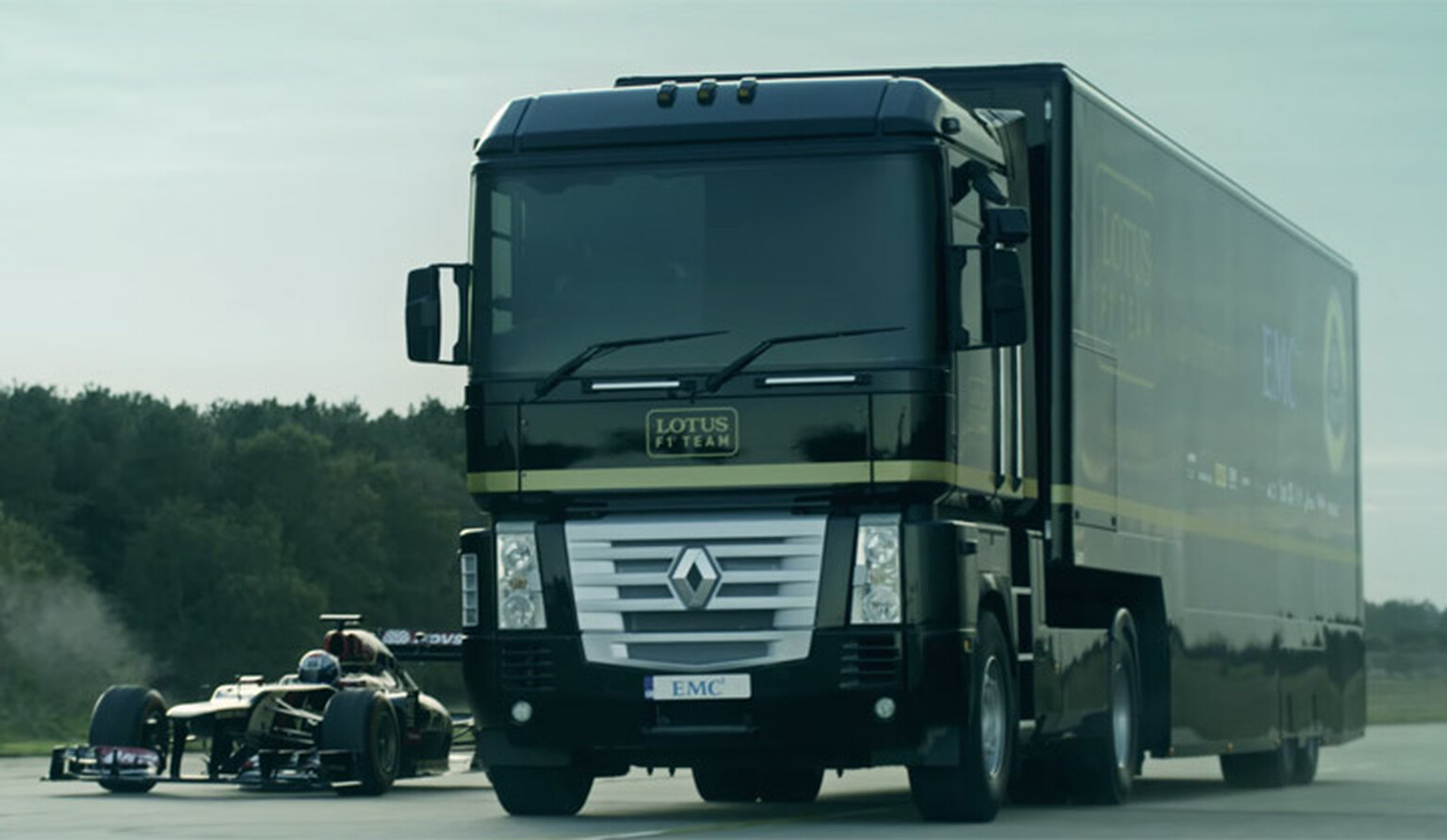 Really big truck jumps over a Formula One car