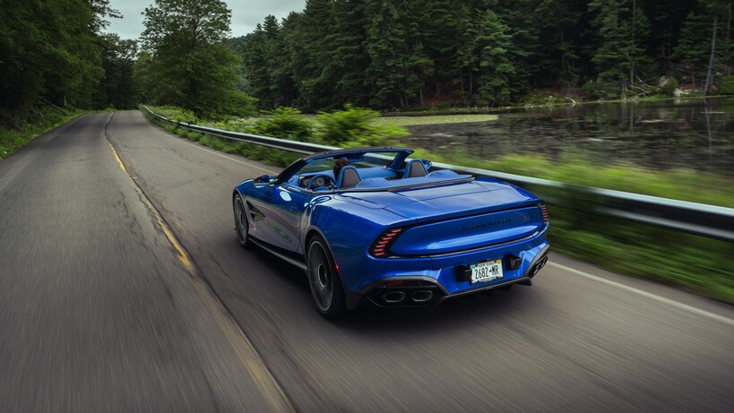 Aston Martin Vanquish driving by a lake