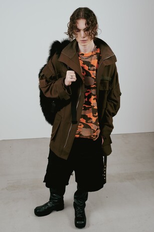 Ambush image showing a man wearing a sturdy coat and baggy trousers