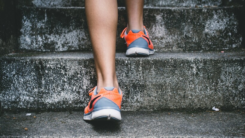 Person walking up stairs in trainers
