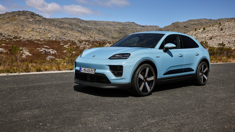 Blue Porsche Macan beside a rocky hill