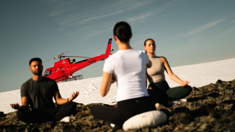 Guests practising guided wellness on a secluded mountaintop overlooking the Coast Mountains near Whistler