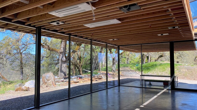 Mendocino House by Jensen Architects featuring concrete walls, steel roofing and large glass panels among oak woodland